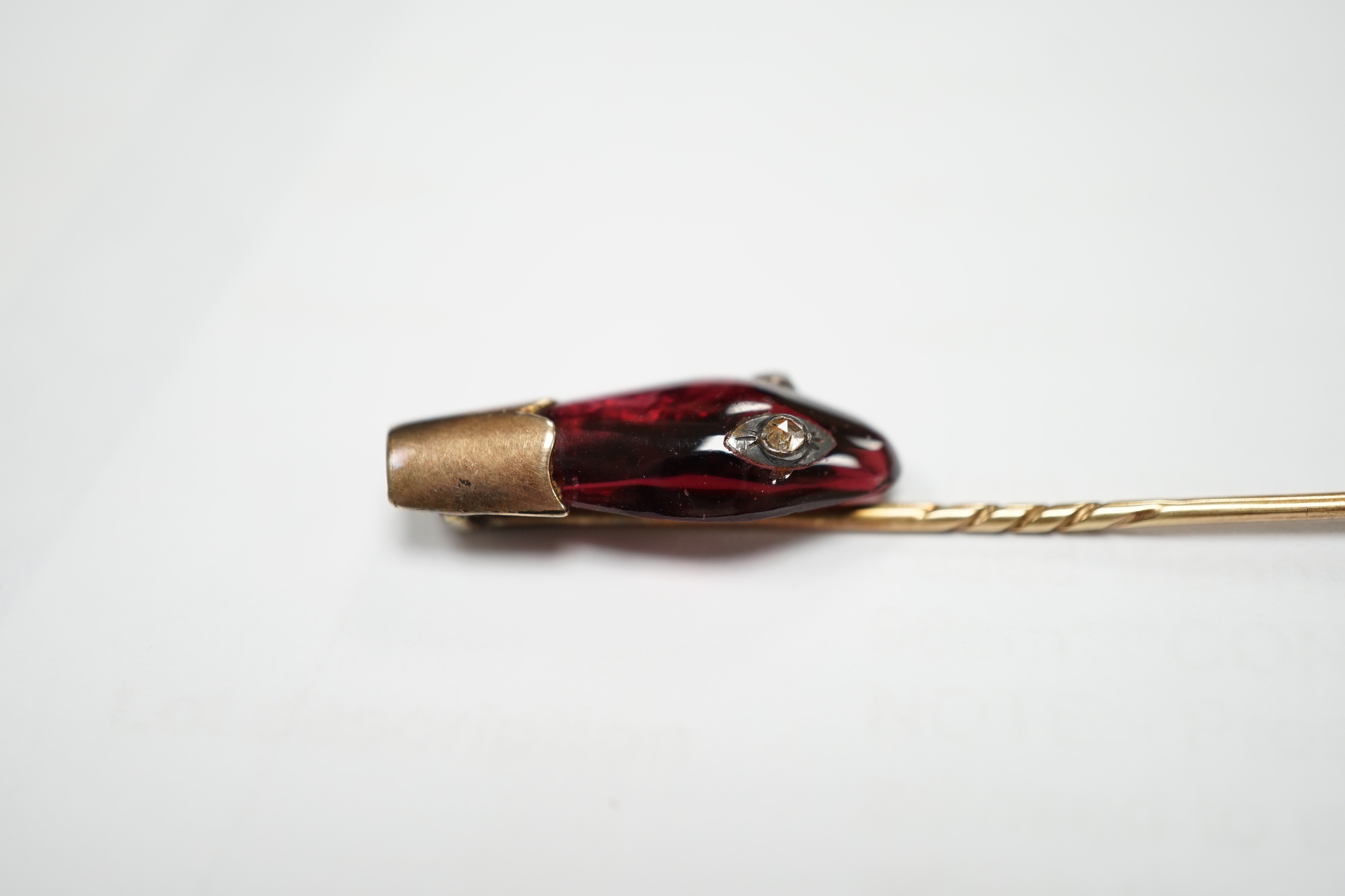 A late Victorian yellow metal, garnet and diamond set serpent head stick pin, 65mm, gross weight 2.9 grams (chip).